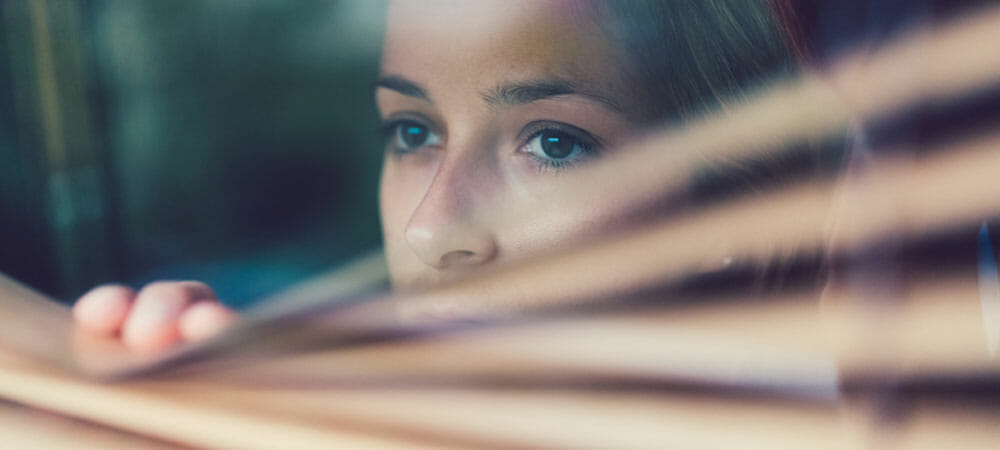 trauma therapy - woman looking through blinds